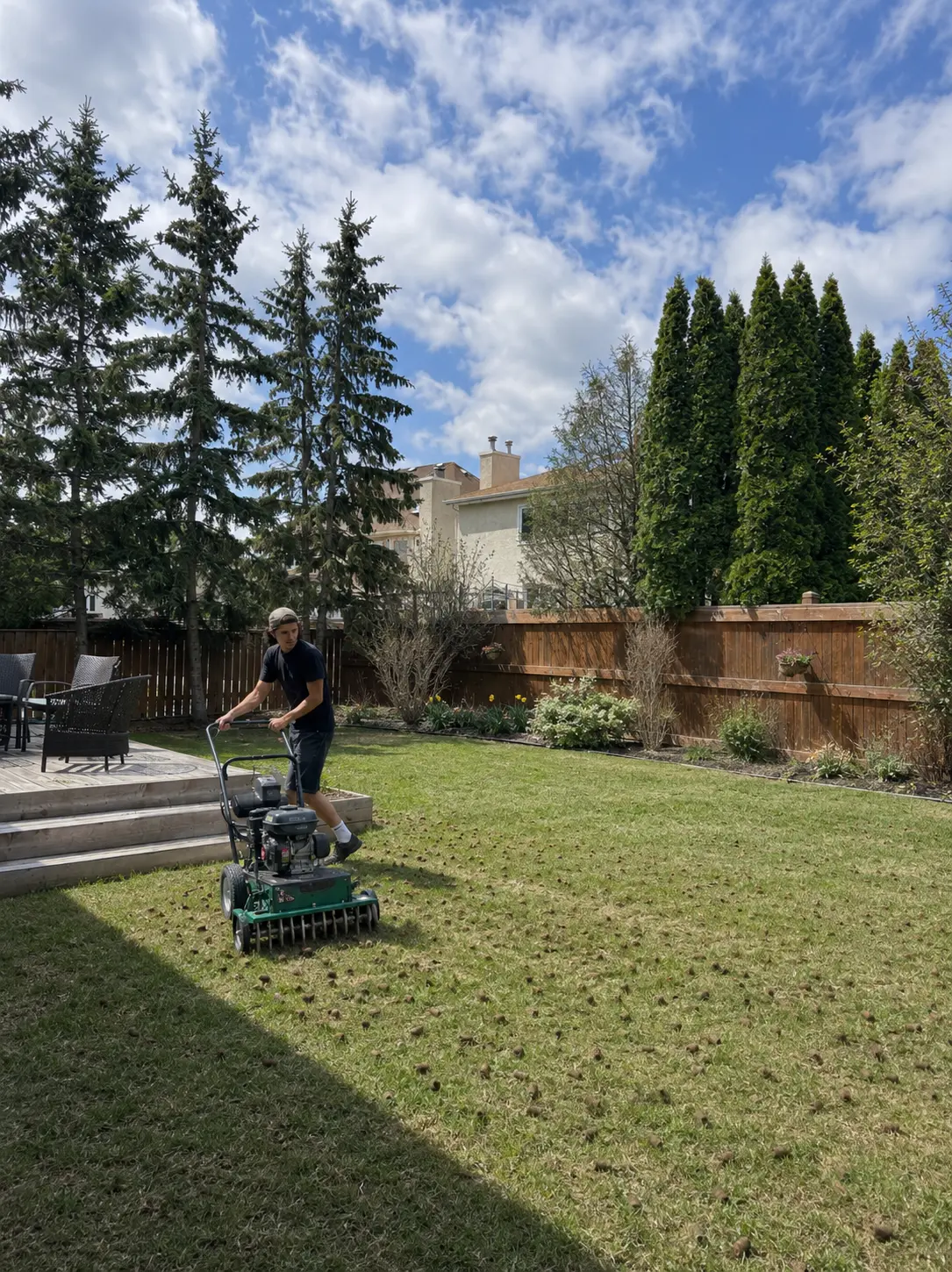 Keystone crew member aerating a residential backyard lawn